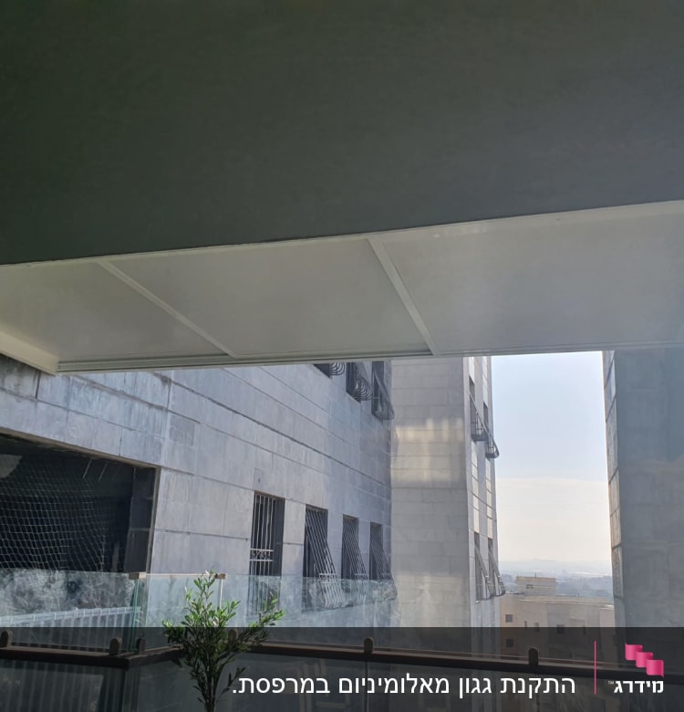 גג אלומיניום מעל מרפסת עם מעקה זכוכית